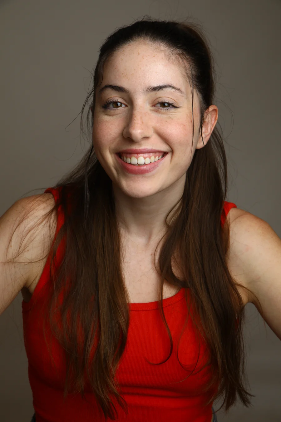 Smiling commercial headshot in a red top