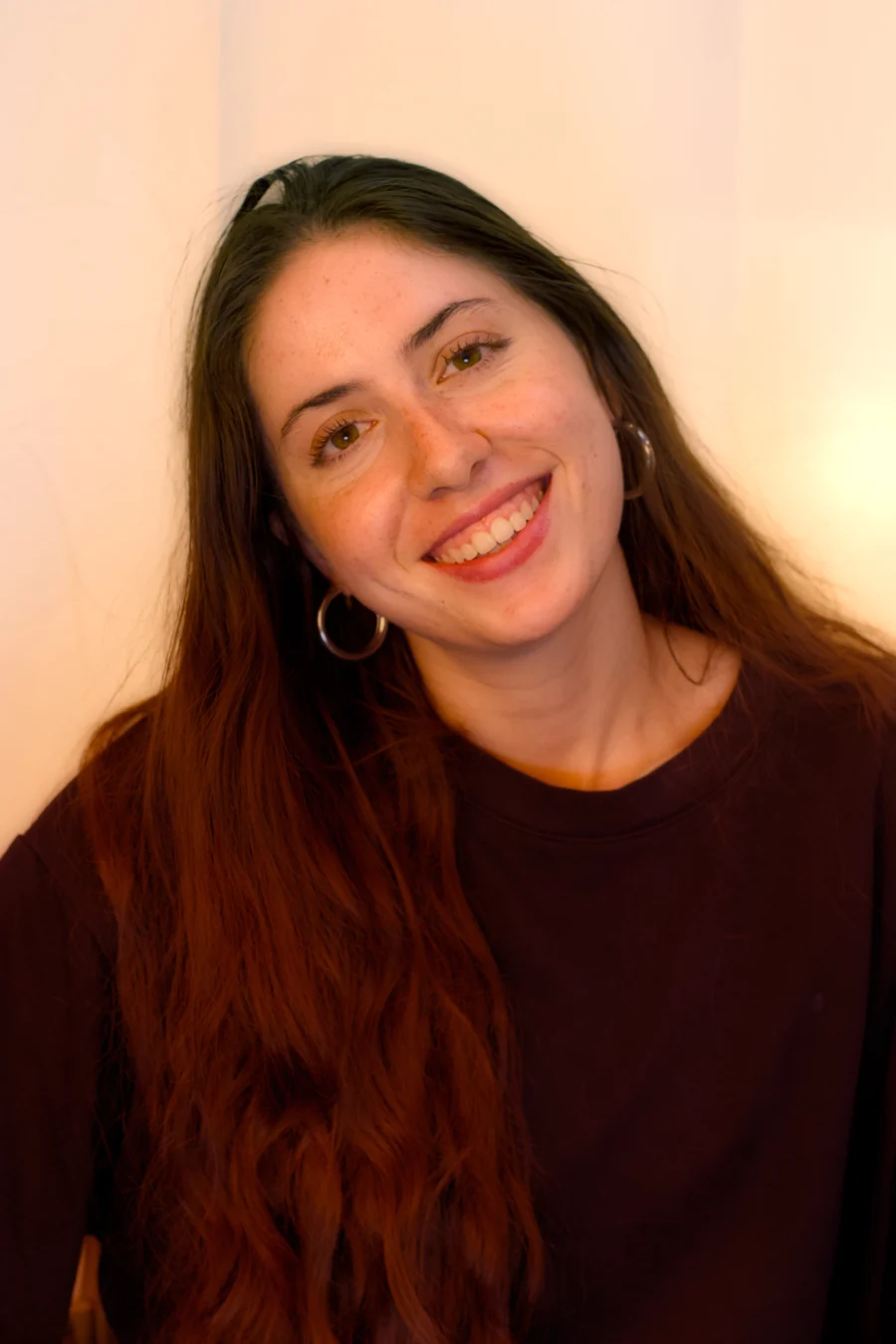 Warm smiling portrait with hoop earrings in golden light